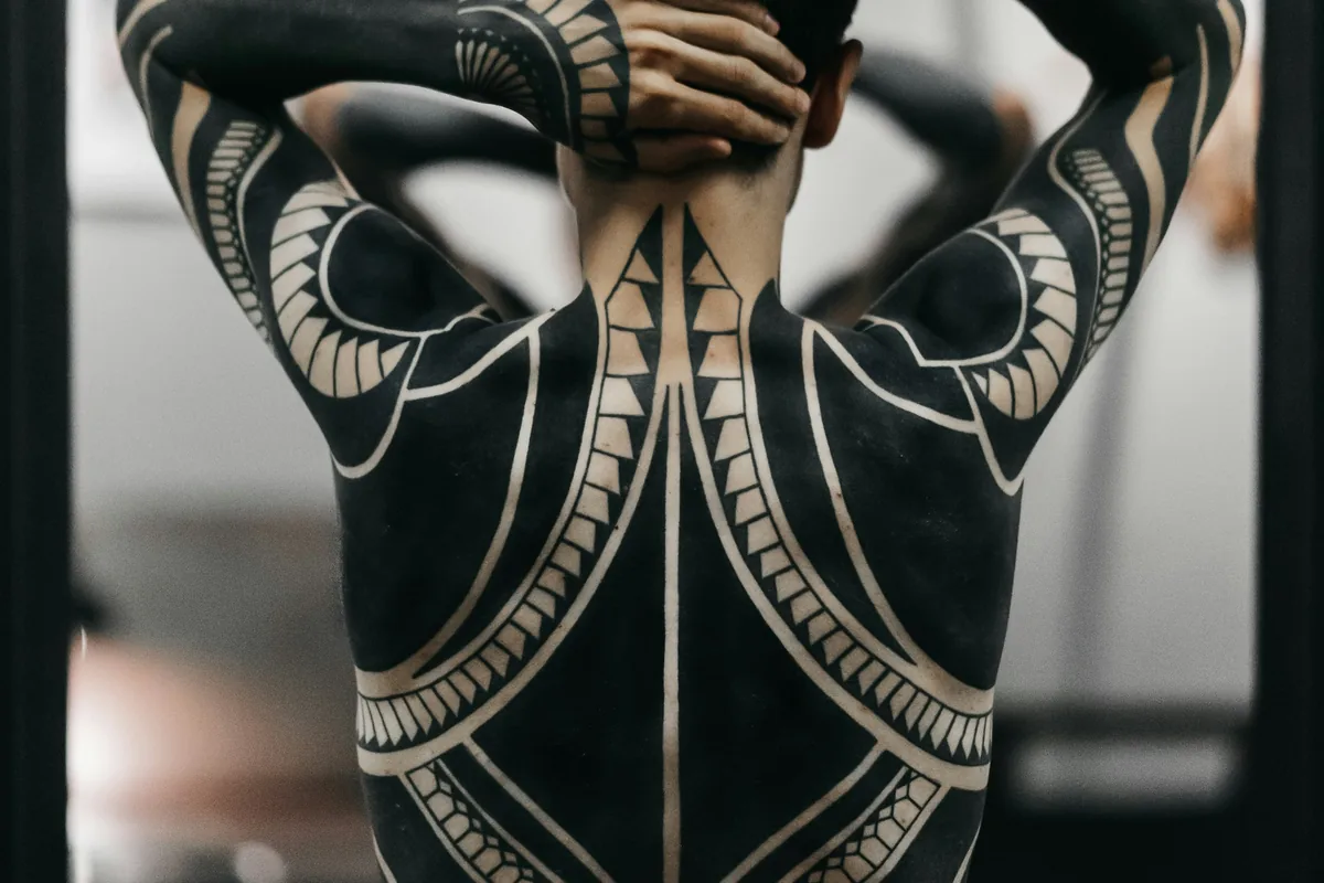 Ornamental blackwork tattoo covering a full back and arms, a dense style that suits a tattoo cover up in Malaysia