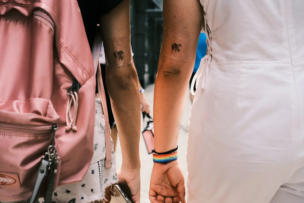 Two people walking with matching small couple tattoos on their arms