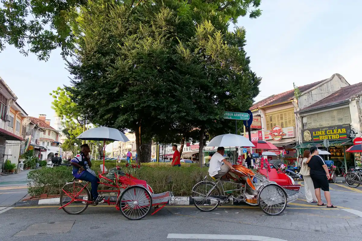 Trishaws parked on a street of heritage shophouses in George Town, Penang
