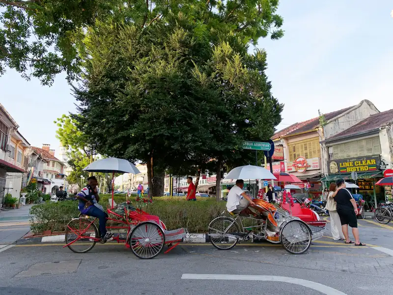 Trishaws parked on a street of heritage shophouses in George Town, Penang