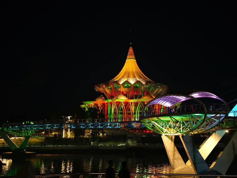 Sarawak State Legislative Assembly building and Darul Hana Bridge lit up at night in Kuching