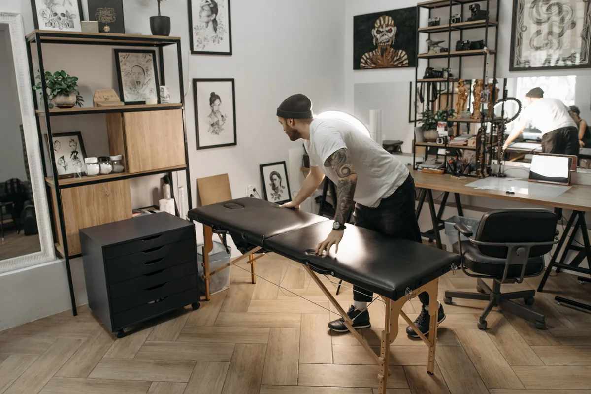 Tattoo artist preparing a clean client bed, illustrating hygiene questions in our tattoo FAQ for Malaysia