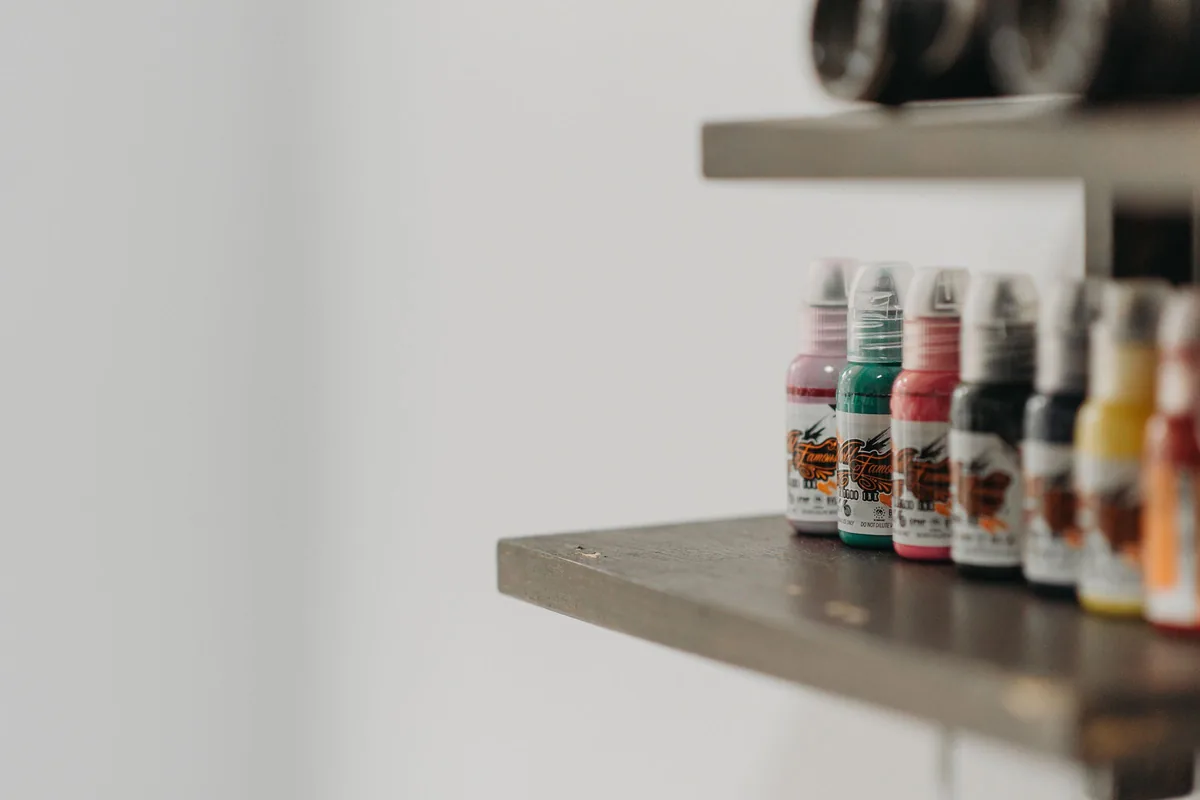 Bottles of coloured tattoo ink on a studio shelf, the kind of products behind questions about halal tattoo ink