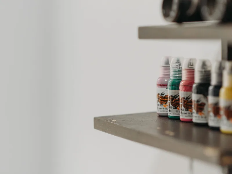 Bottles of coloured tattoo ink on a studio shelf, the kind of products behind questions about halal tattoo ink